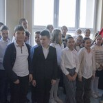 Dzieci trzymaja flagę i pozują do zdjęcia