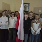 Dzieci trzymaja flagę i przygotowują się do śpiewu hymnu