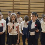 Chłopiec i dziewczynka występuje na apelu z okazji Święta Niepodległości