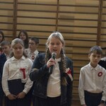 Dziewczynkarecytuje wiersz na apelu z okazji Święta Niepodległości
