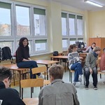 Uczniowie siedzą w okręgu podczas warsztatów.