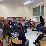 Uczniowie siedzą w okręgu podczas warsztatów.