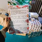 List dla rodziny na tle choinki i prezentów.