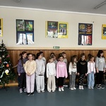Uczniowie klasy 2A wykonują pastorałkę. Dzieci stoją razem_ śpiewają_.jpg