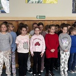Uczniowie klasy 2D stoją razem i śpiewają kolędę.