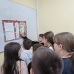 Uczniowie stoją przy tablicy. Na tablicy wisi list od Mikołaja. Uczniowie szukają swoich imion w liście.