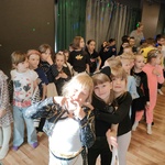 Uczniowie stoją w dwóch rzędach. Patrzą w prawą stronę