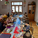 Uczniowie pracują przy prostokątnych stołach. 