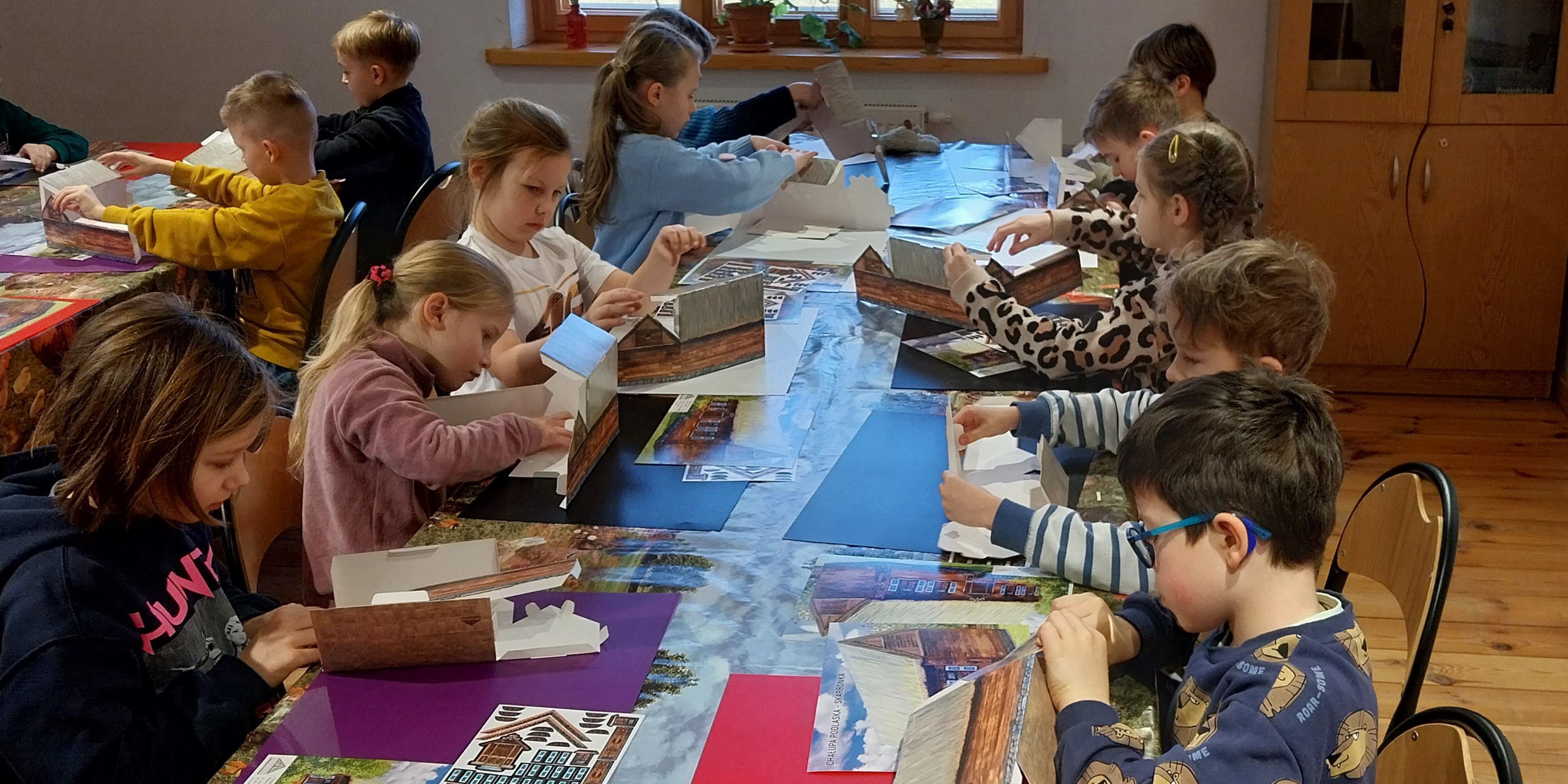 Uczniowie pracują przy prostokątnych stołach. (1).jpg