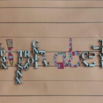 Na beżowym tle w linie ułożone są drewniane litery tworząc słowo ALPHABET. 