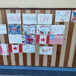 Gazetka ścienna na szkolnym korytarzu z napisem „English Language Day” oraz pracami uczniów przedstawiającymi flagi krajów anglojęzycznych i rysunki związane z nauką języka angielskiego.