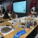 Uczniowie obserwują prezentację dotyczącą elektrochemii oraz stanowiska laboratoryjne przygotowane do wykonywania doświadczeń.