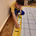 dziecko koduje na planszy na podłodze