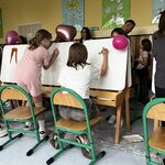 Uczniowie rysują portrety swoich mam