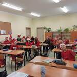 uczniowie pozują do zdjęcia w mikołajkowych strojach