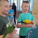 uczniowie pozują do zdjęcia z papugami
