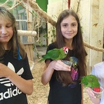 uczennice pozują do zdjęcia z papugą