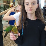 uczennica pozuje do zdjęcia z papugą