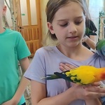 uczennica pozuje do zdjęcia z papugą