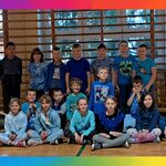 uczniowie ubrani na niebiesko pozują do zdjęcia