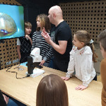 uczniowie obserwują organizmy pod mikroskopem