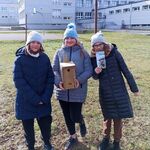 uczennice pozują do zdjęcia z budką lęgową