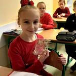 uczennica pozuje do zdjęcia z drewnianą bombką